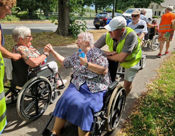 twee oudere dames in rolstoel tijdens evenement ondersteund door Nh1816 Verzekeringen